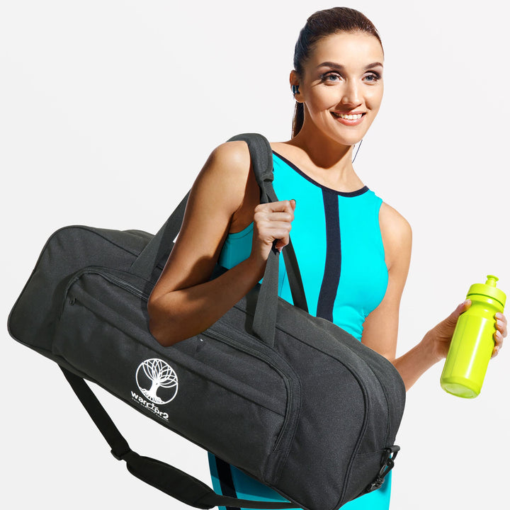 Woman holding a black Warrior2 yoga duffle bag with shoulder strap and a neon water bottle, wearing turquoise activewear and smiling