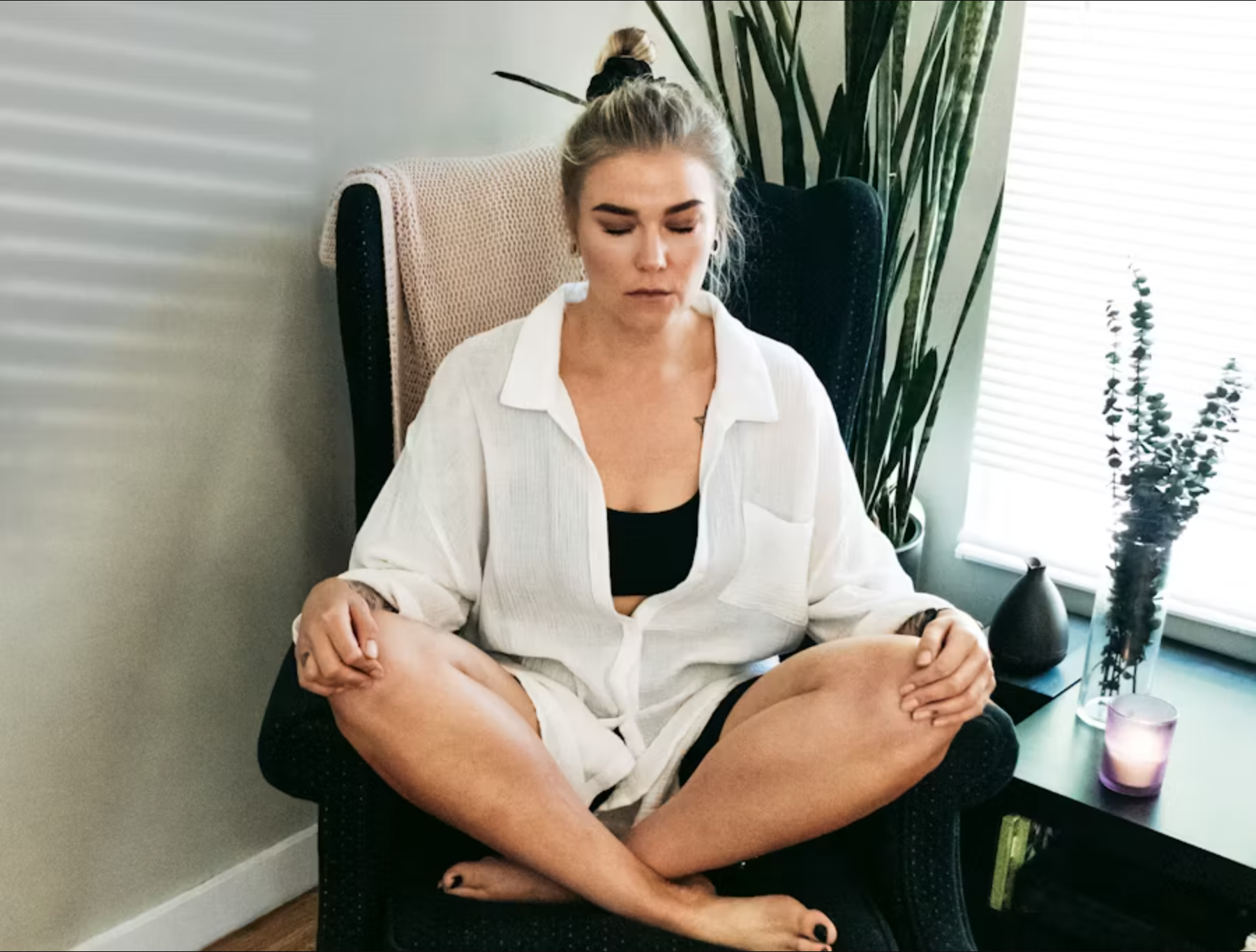 Person demonstrating a seated yoga pose using a chair for support, ideal for those using a yoga mat carrier for transport