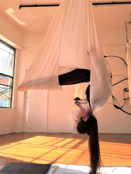 woman yoga class aerial mosquito pose