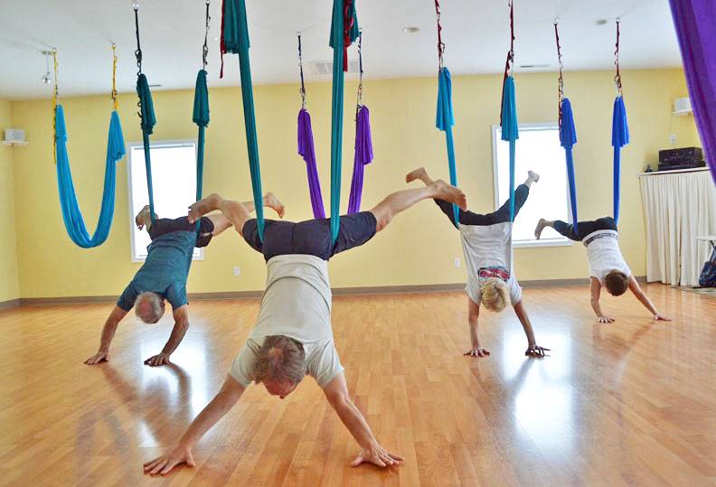 middle aged group people aerial yoga class