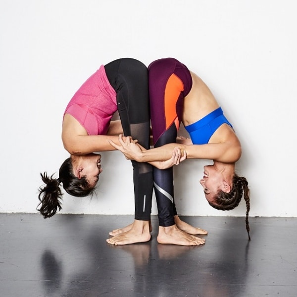 2 person perform standing foward bend pose