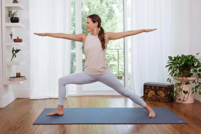 woman doing warrior2 pose daytime yin yoga encourages calmness