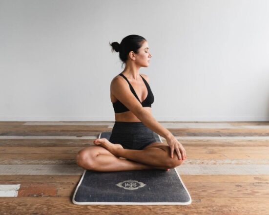 woman doing yin yoga studio wooden floor twist pose