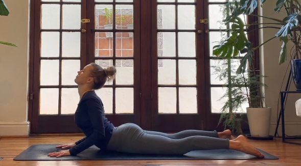 woman cobra yoga pose daytime indoor morning practice