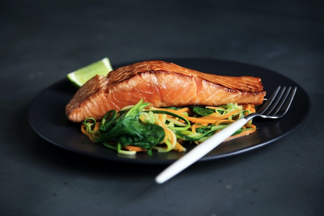 healthy salmon salad black plate background avoid heavy meals aerial yoga