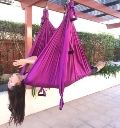 person laying hammock aerial yoga avoid overperform