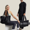 a guy standing next to a girl both carrying warrior2 black yoga totes