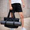 man in black shorts holding warrior2 black yoga gym bag